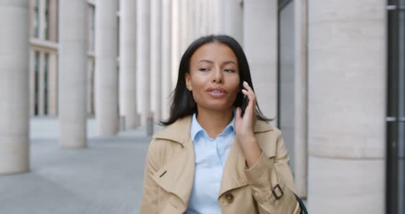 Young Black Businesswoman Making Phone Call Outdoors Commuting to Work
