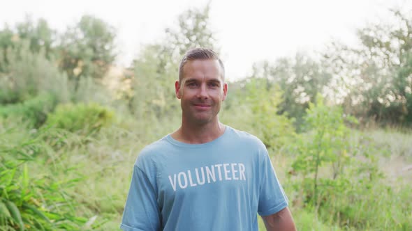 Caucasian man smiling and looking at camera during river clean-up day