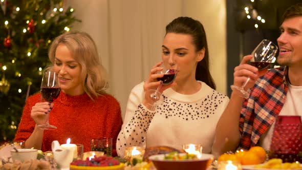 Happy Friends Drinking Red Wine at Christmas
