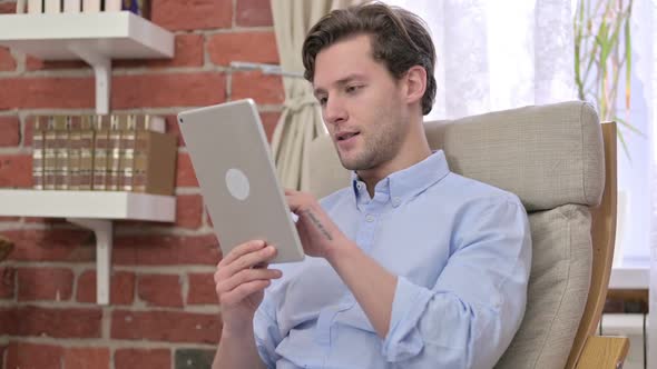 Young Man Using Tablet in Modern Office