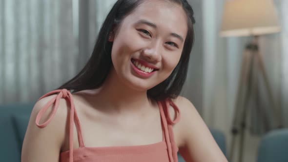 Close Up Of Asian Woman Smiling To Camera While Slicing The Cucumber At Home