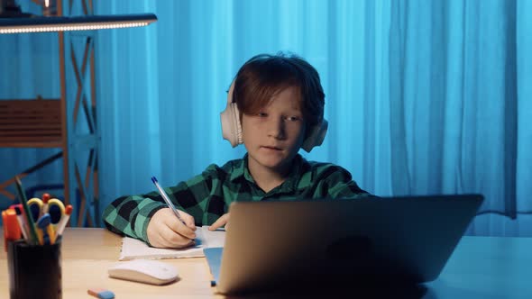 Little Boy Studying Online Using Video Call on Laptop