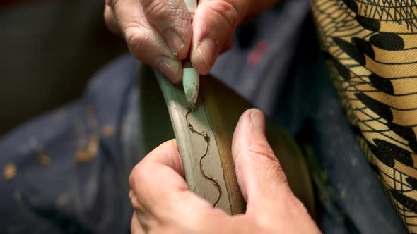 Potter Painting on Bowl in Pottery Workshop