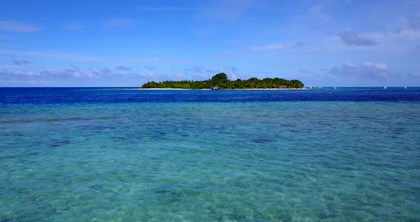 Wide angle birds eye travel shot of a paradise sunny white sand beach and aqua blue water background