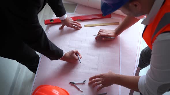 From Above Crop Businessman and Contractor Drawing Draft on Table