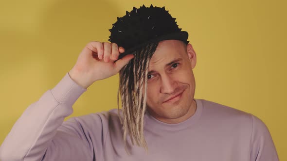 Young Handsome Man in Black Cap Posing on Yellow Background