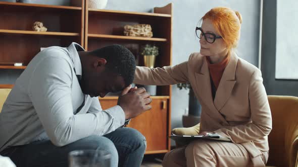 Female Counseling Psychologist Supporting Stressed Black Man