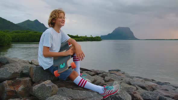 Boy with a Longboard on a Beautiful Beach