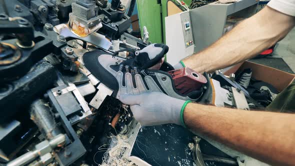 Footwear Worker is Using a Machine to Adjust a Shoe