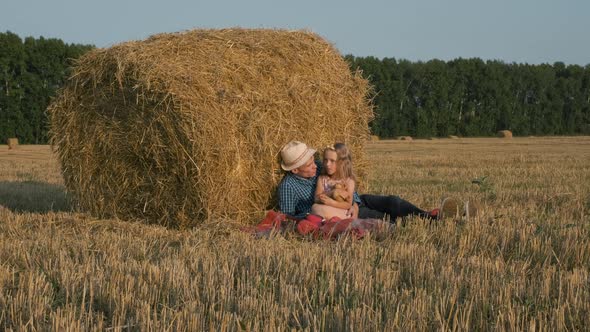 Little Girl with Father Relax in Harvested Field