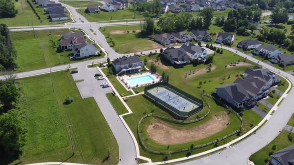 People out in suburban home community playing tennis on the tennis court