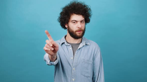 Young Bearded Man Waves Finger Saying No to Suggestion