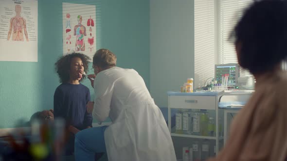 Doctor Examining Girl Throat in Hospital