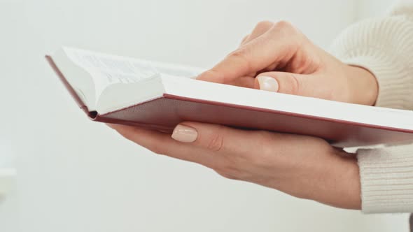 Close Up of Female Hands Turning Pages of a Book