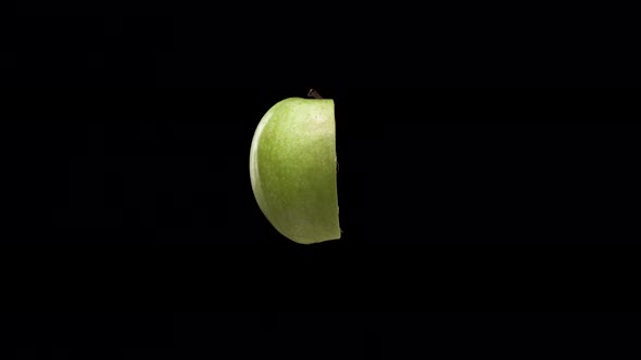 Quarter of Delicious Green Tasty Apple Rotate or Spin on Black Background. Healthy Eating Concept To
