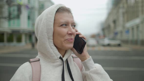 Portrait Of Woman Typing By Mobile Phone Outdoors