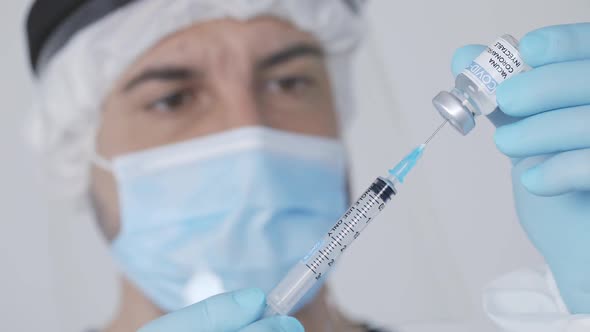 Crop doctor filling syringe with drug in hospital