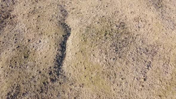 Aerial drone shot of a country region with hiils and dead vegetation in autumn season, daytime