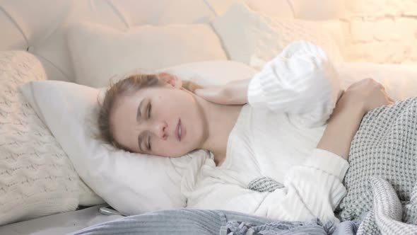Woman with Neck Pain lying in Bed