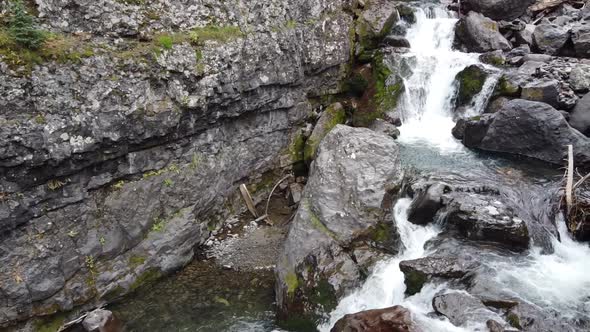 Aerial From Gorge with Dozens of Small Waterfalls Up Edge of Rock Wall