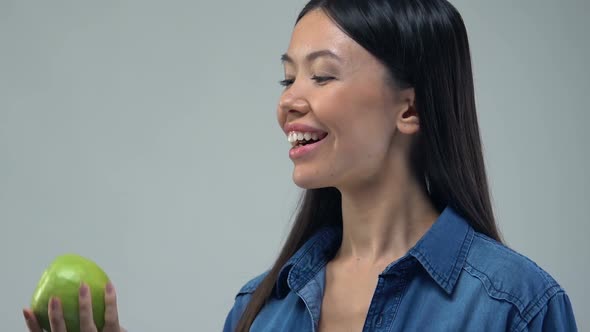 Smiling Asian Girl Holding Green Apple, Low Calories Food, Vitamins and Minerals