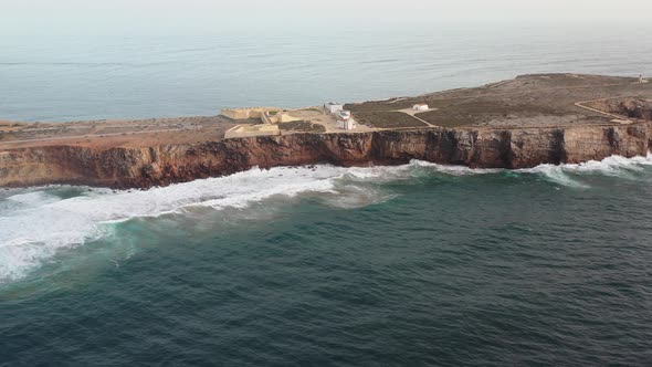 Cape Sagres Portugal with Sagres Fortress on top of the eroding land, Aerial approach reveal shot