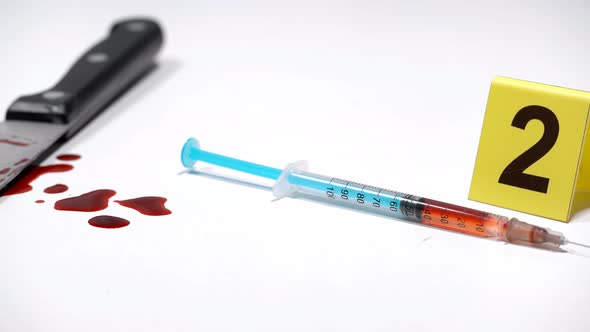 Syringe on a Crime Scene with Drugs and a Knife in the Blood