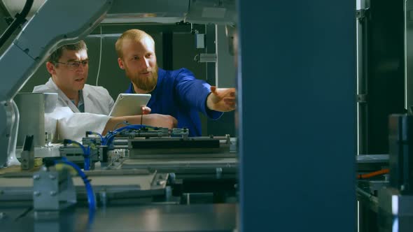 Robotic engineers checking machinery in warehouse 4k