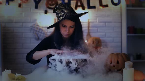 Beautiful Witch Performing Mysterious Magic Ritual, Cooking Potion in Cauldron
