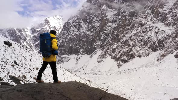 Tourist on Mountain Top. Sport and Active Life. Hiker with Backpack Standing on Top of a Mountain