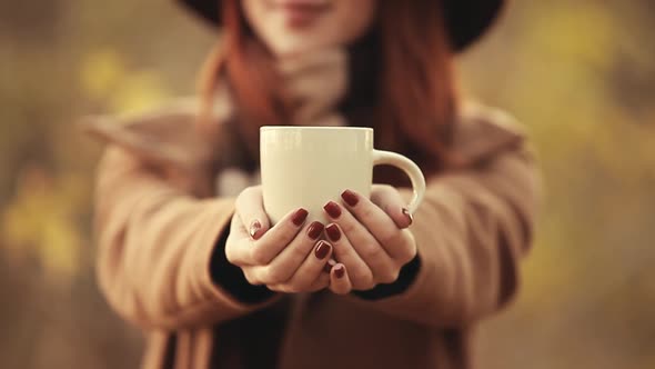 Woman hold white cup in hands, Autumn season time