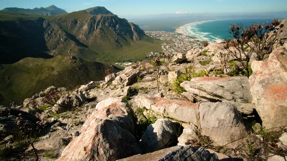 Tilt-up shot from top of mountain of pristine beach along coastline, Hermanus, South Africa