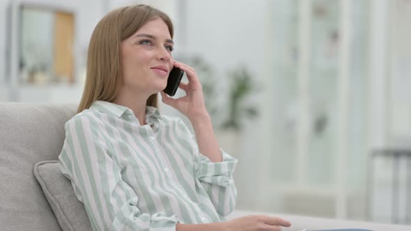 Cheerful Young Woman Talking on Smartphone at Home 