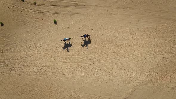 Aerial view of people riding horses in the desert of Al Khatim in Abu Dhabi.