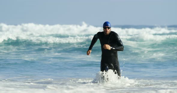 Male surfer running in the beach