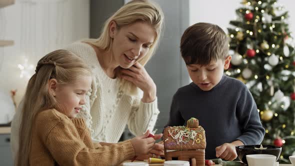 Video of children and mother decorating gingerbread house. Shot with RED helium camera in 8K.