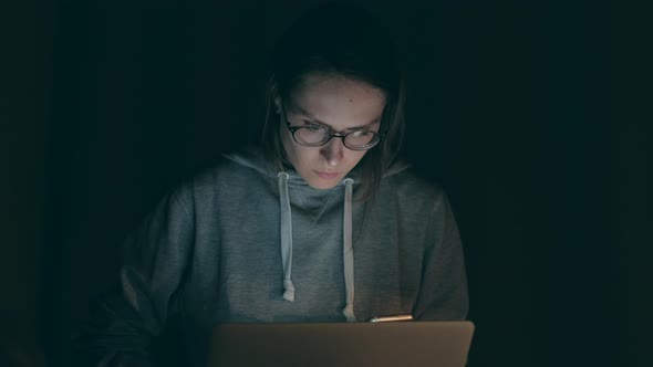 Brunette Girl Working on Notebook in the Night at Home