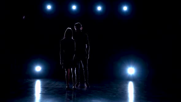 Young Couple Dancing Contemp Against Black Background with Spotlights at Studio, Slow Motion.