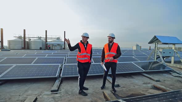 Workers are Talking About Innovative Technologies on the Modern Photovoltaic Farm