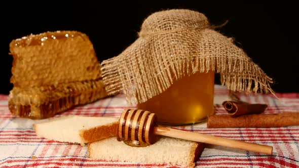 Honey Spoon Dripper, Jar with Stick Pouring Over Toast Bread, Honeycomb on Black