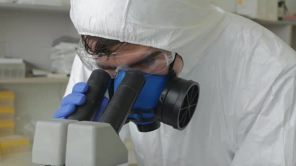 Virologist Scientists a Man and a Woman Take Turns Looking Through a Microscope Discussing and alt