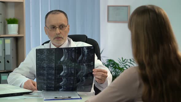 Attentive Surgeon Looking at Neck X-Ray, Working on Diagnosis, Appointment