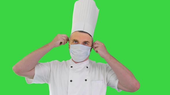 Male Chef Cook Taking Medical Mask Off and Smiling To Camera on a Green Screen Chroma Key