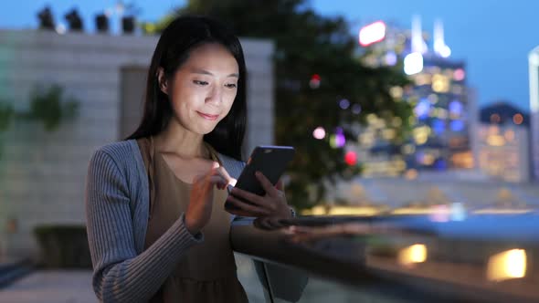 Woman using smart phone in Hong Kong at night 