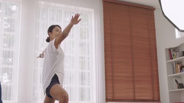 Asian woman working out in sportswear, performing yoga or pilates.