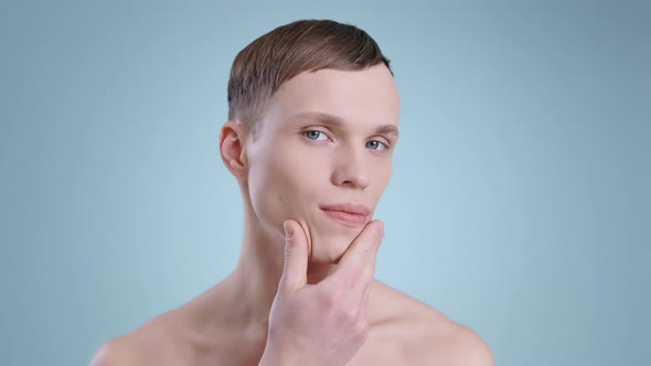 Portrait of Attractive Man Touching Face with One Hand While Looking to Camera