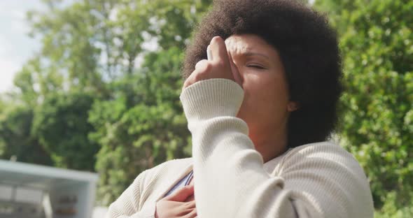 Video of plus size african american woman using inhalator outdoors