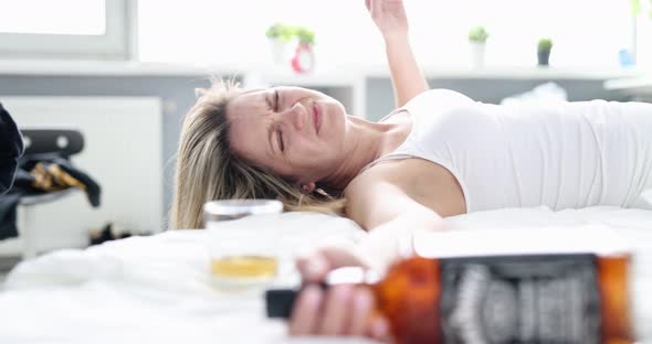 Drunk Woman with a Alcohol on the Bed Closeup