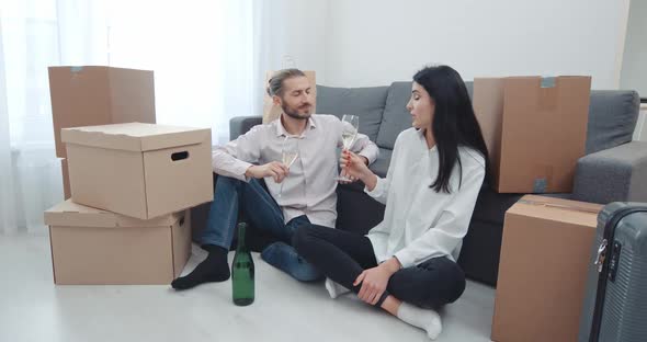 Housewarming Celebration a Young Couple Sitting on the Floor Near Boxes of Things Talking and