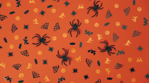 abstract creative composition of small Halloween decorations rotates on an orange background. 4k.